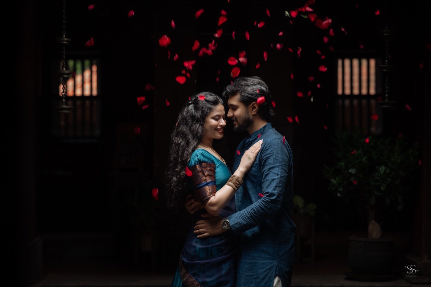 Rohan and Ananya in a courtyard with rose petals falling